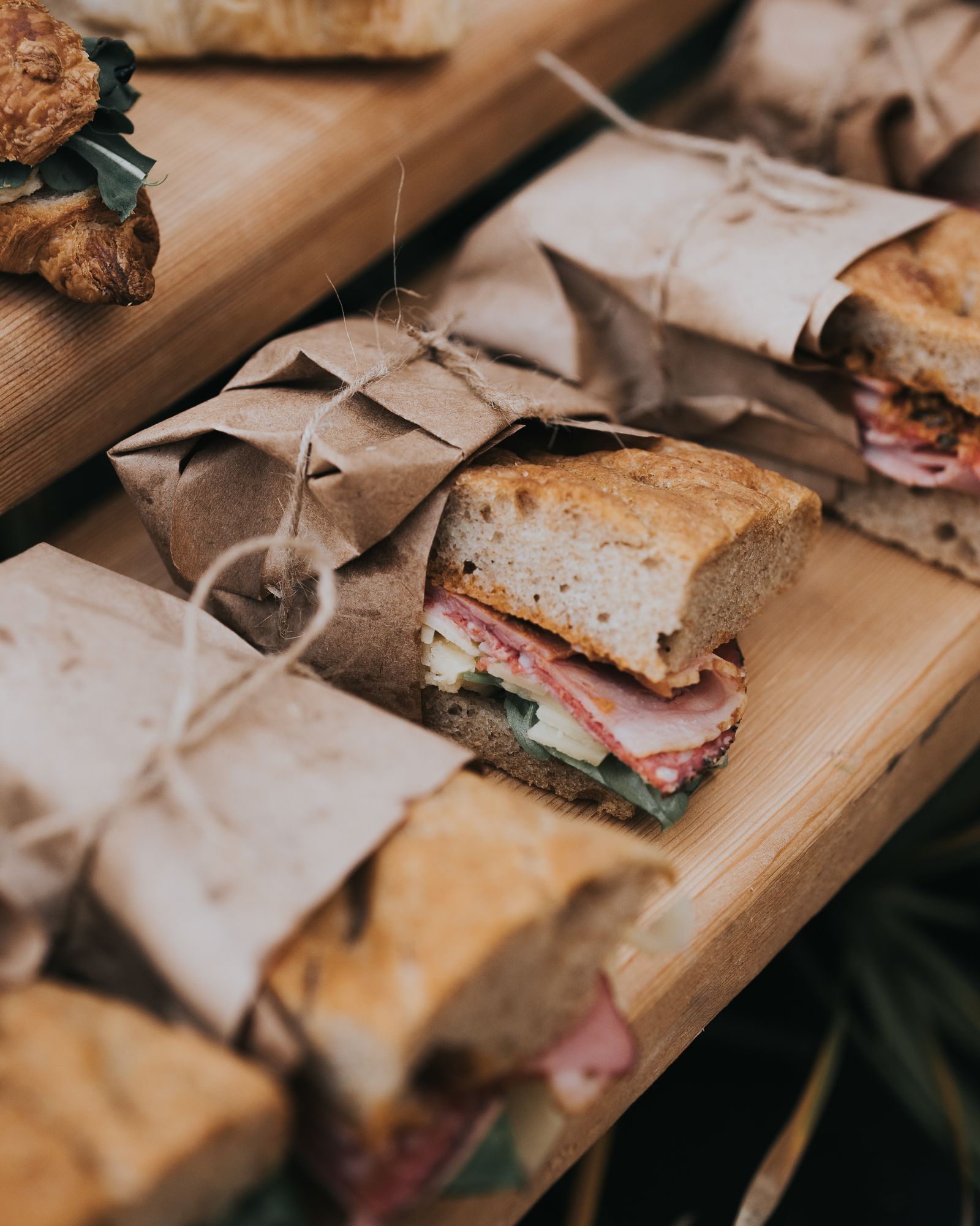 Subs wrapped in paper and tied with twine on the counter