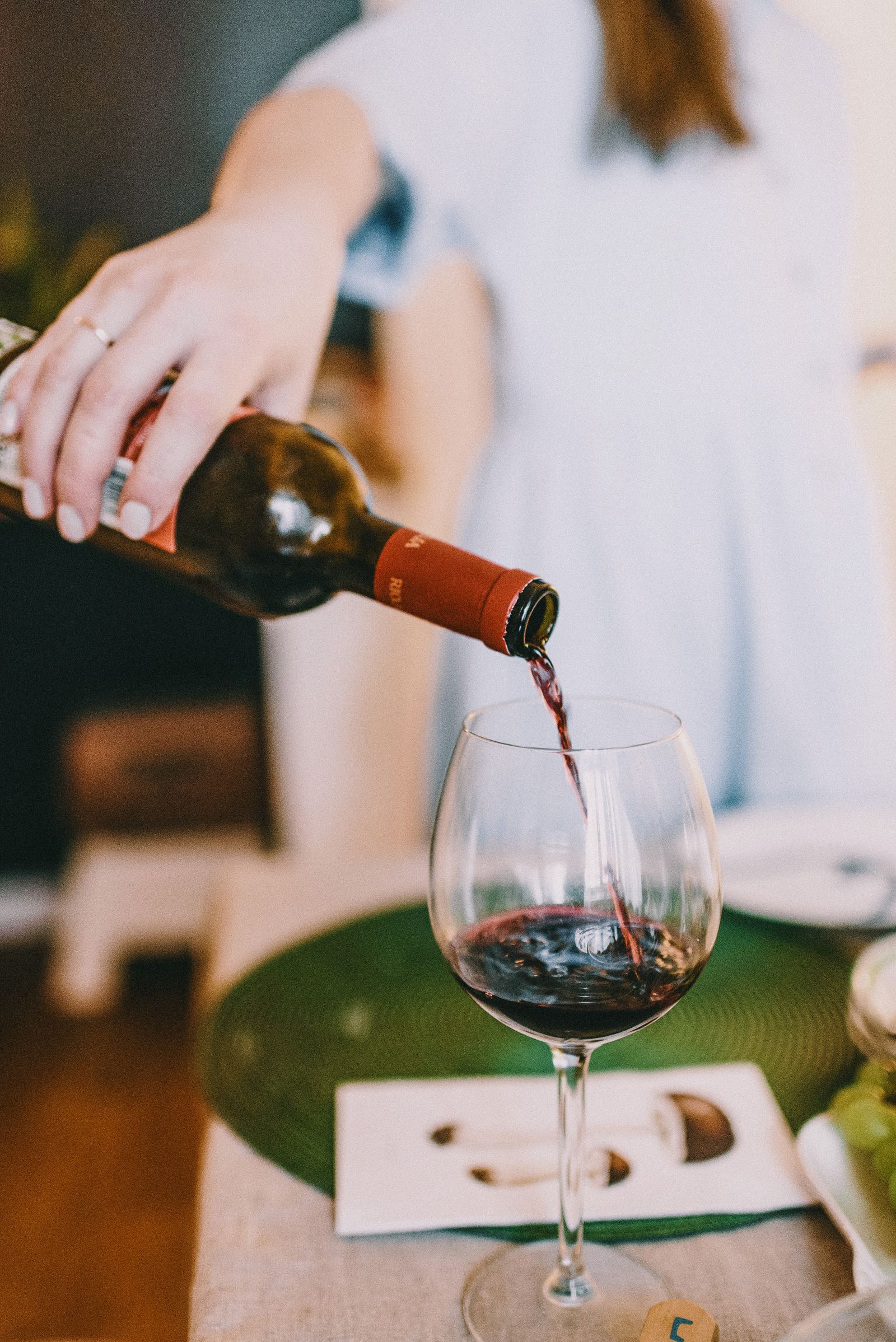 A glass of red wine being poured